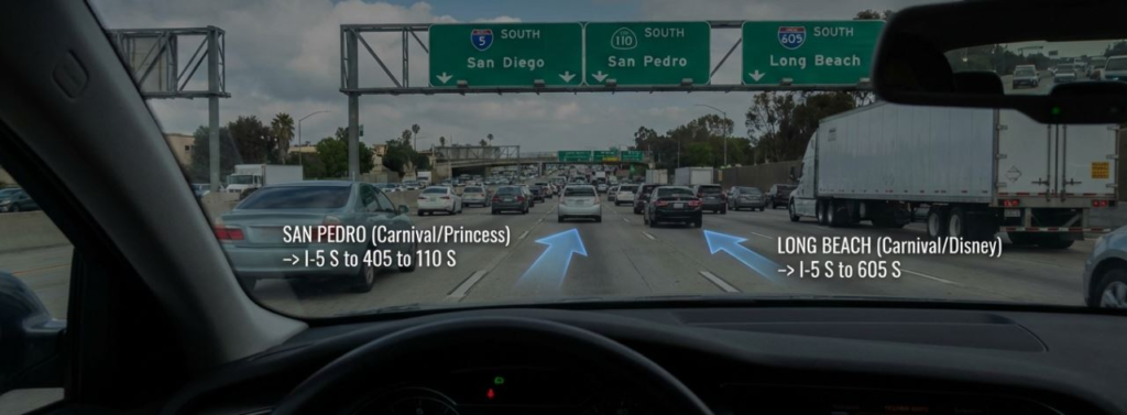 Driving on a busy freeway towards San Pedro and Long Beach with highway signs and traffic visible through the windshield.